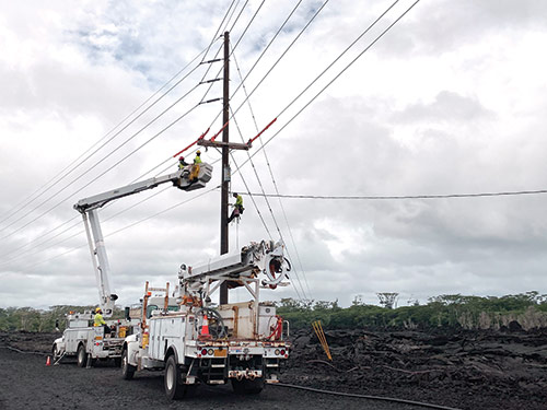 Hawaiian Electric is working closely with Ormat Technologies to bring the Puna Geothermal Venture plant back online. Here, utility linemen are restoring a line to bring some power in for the reconstruction project.